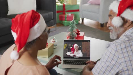 Happy-senior-african-american-couple-on-video-call-with-happy-boy-at-christmas-time