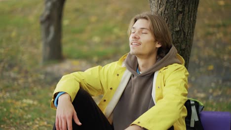 Young-hiker-resting-in-forest,-traveling-and-hiking-alone,-enjoying-nature