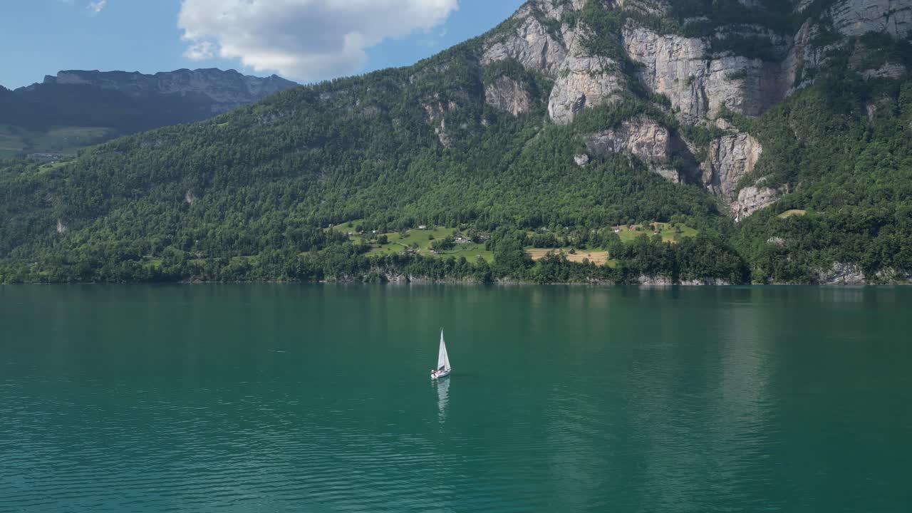 toma de arco de un avión no tripulado de un yate navegando en las aguas tranquilas y pacíficas del lago walensee belleza natural