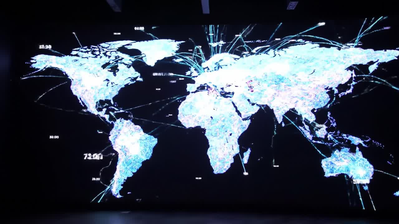 An interactive display showcases a detailed map of the world illuminated by vibrant data patterns, illustrating global connections and network behavior.