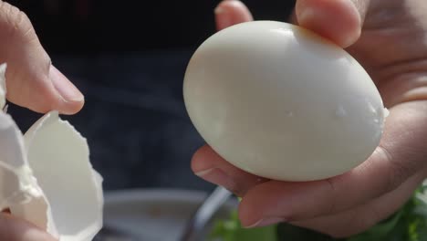 person peeling a boiled egg