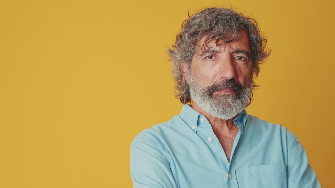 Mature Man with Beard Turns Head and Looks at Camera