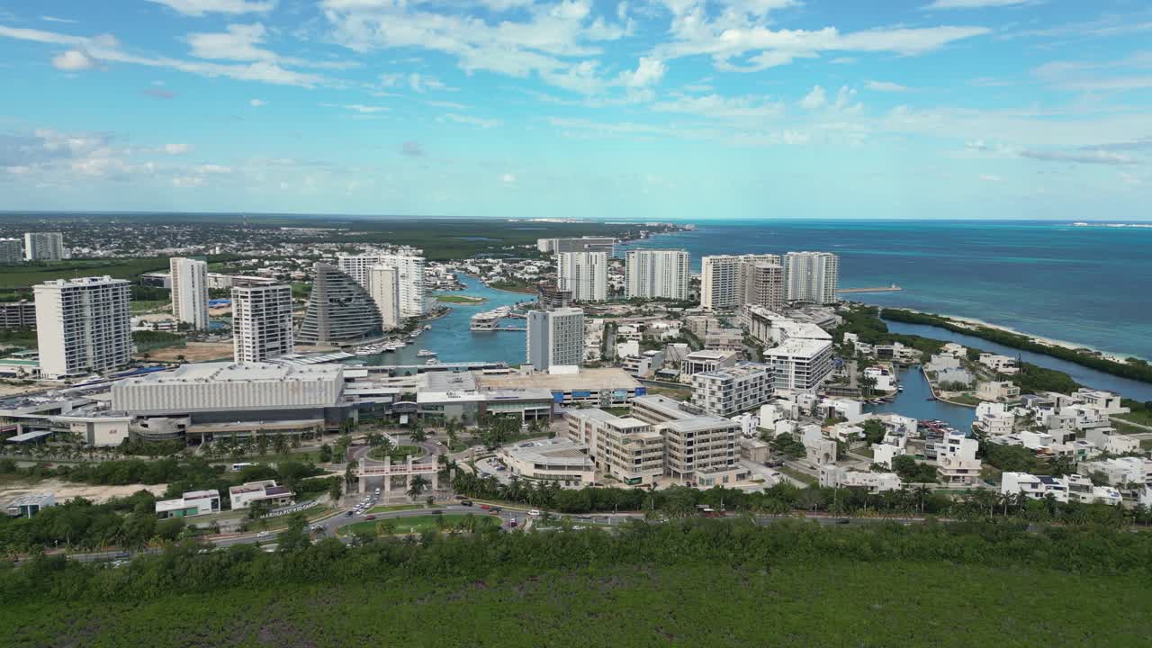 Aerial flight over mangrove swamp to highrise hotels in Cancun, Mexico