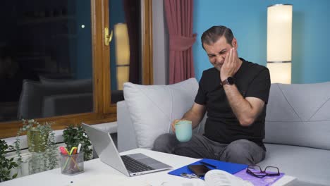 home office worker man has tooth sensitivity.