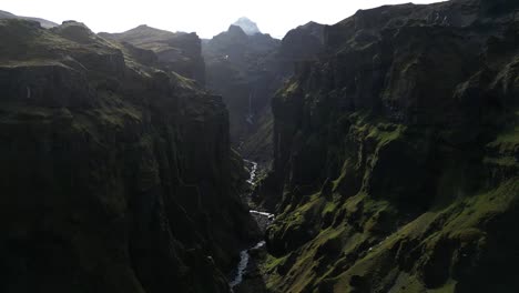 Aerial-view-in-the-middle-Múlagljúfur-Canyon-surrounded-by-small-river-streams,-beautiful-mountains,-vibrant-textures,-and-incredible-rock-formations-in-the-summer-of-Iceland