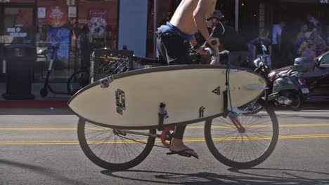 Mann-Radfahren-Mit-Einem-Surfbrett