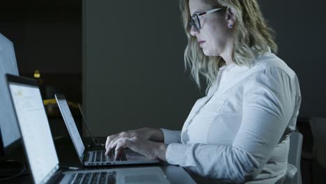 focused businesswoman in eyeglasses using computer