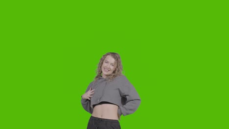 studio shot of young woman having fun dancing against green screen 14