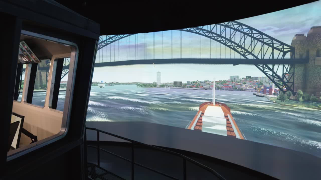 High-tech ship bridge simulator shows a realistic virtual reality scene of navigating a vessel under a large bridge at a maritime university training center