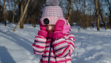 Child-girl-opening-her-mouth-in-amazement,-wow-delight-gesture,-pleasantly-surprise-in-winter-park