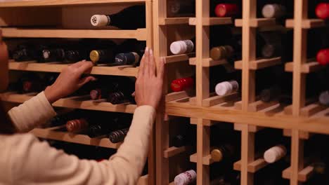 a woman browses a wine rack in a dimly lit cellar, carefully choosing a bottle