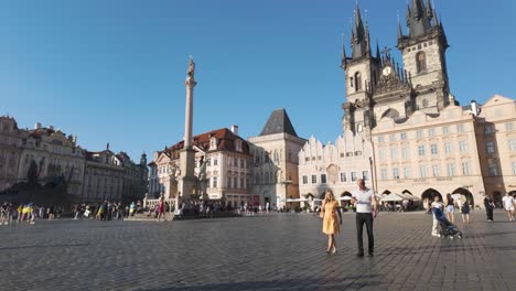 a busy day in prague’s old town square with tourists walking and historic buildings in view