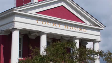 a gold sign marks a white and red building at a court house in montpelier vermont