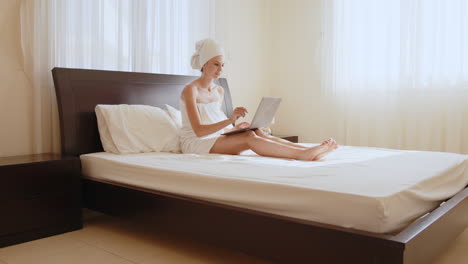 mujer trabajando en la computadora portátil en la cama