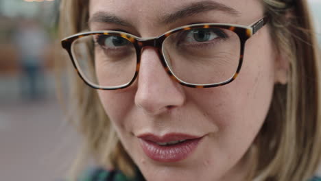 close up portrait of beautiful pensive blonde woman looking at camera smiling happy wearing glasses