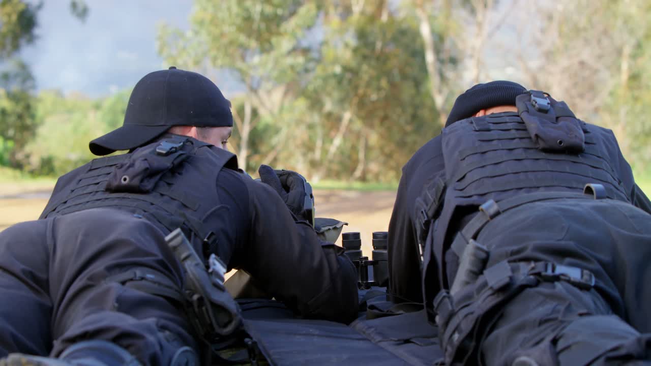 vista trasera de soldados militares caucásicos mirando a través de binoculares y riflescopio en el entrenamiento 4k