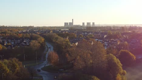 early morning sunrise power station skyline aerial view descending to autumn british townhouse neighbourhood