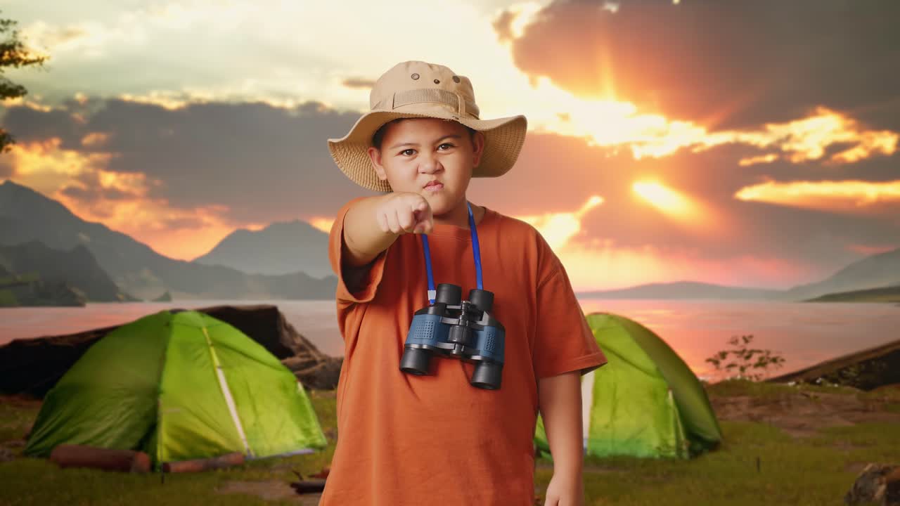 A boy on a camping adventure points at something