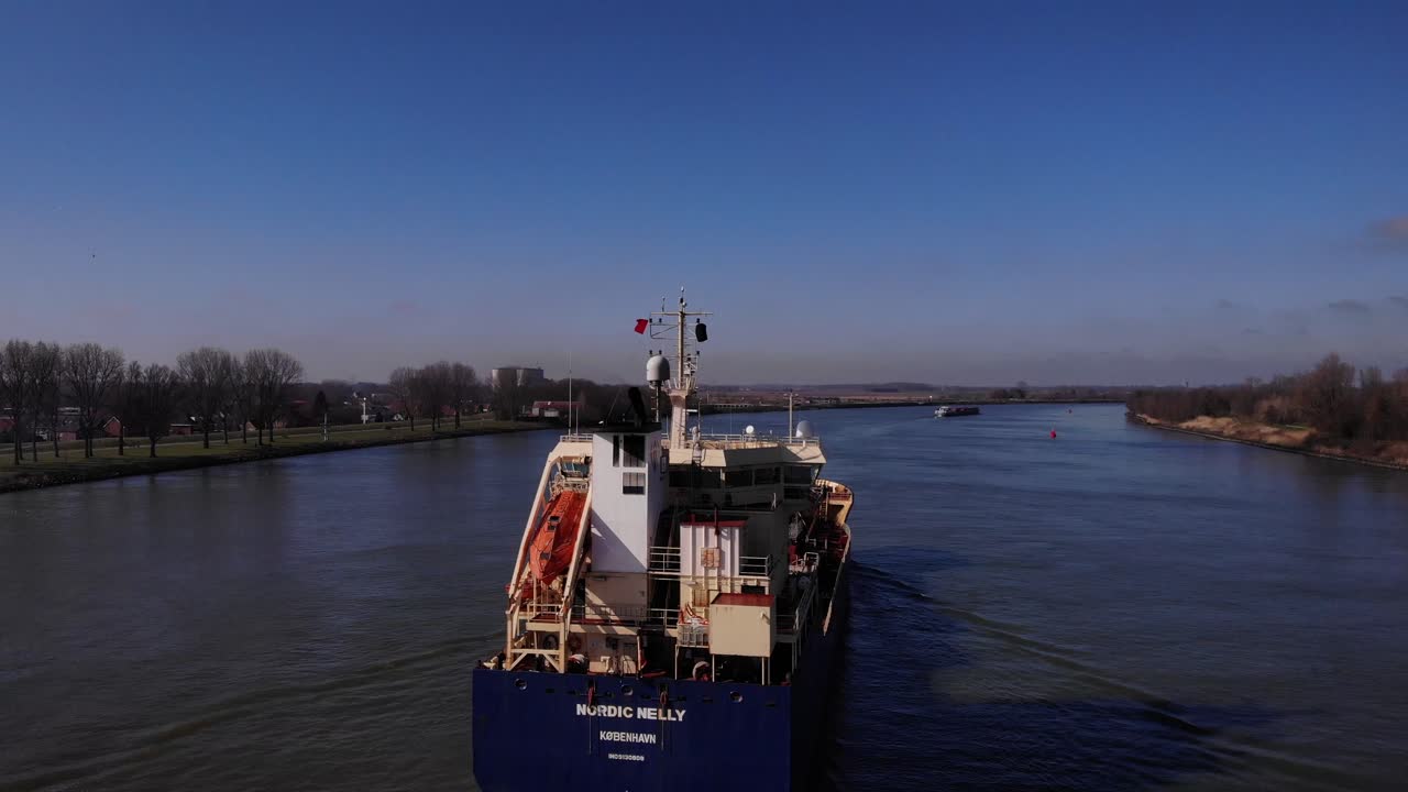 Freight cargo ship in the river. Aerial view by drone on the water