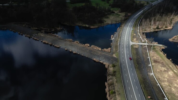 Beautifully lit lake landscape around the expressway with cars passing by