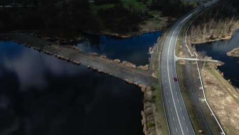 Wunderschön-Beleuchtete-Seenlandschaft-Rund-Um-Die-Schnellstraße-Mit-Vorbeifahrenden-Autos