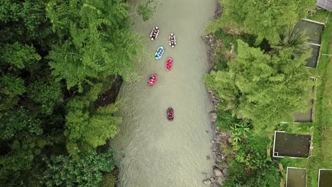 Overhead-drone-camera-following-rafting-boats-on-the-river-with-brown-water