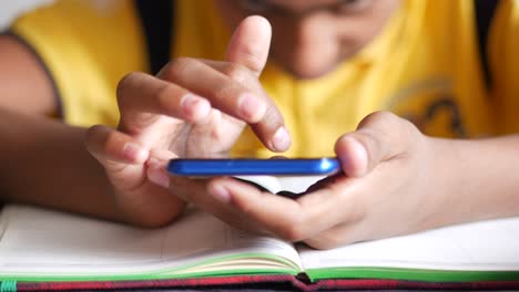 teenage boy sitting on chair using smart phone