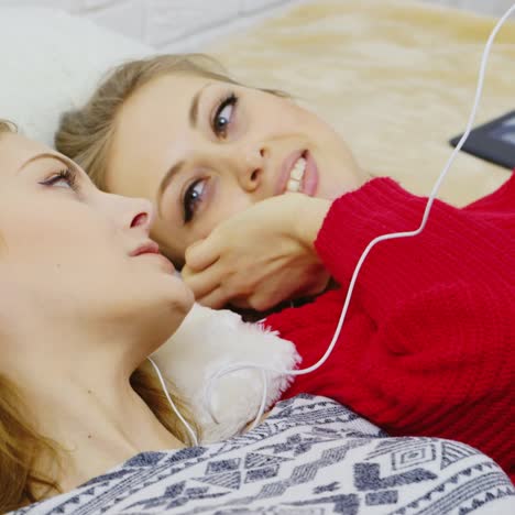 young women listening to music on headphones