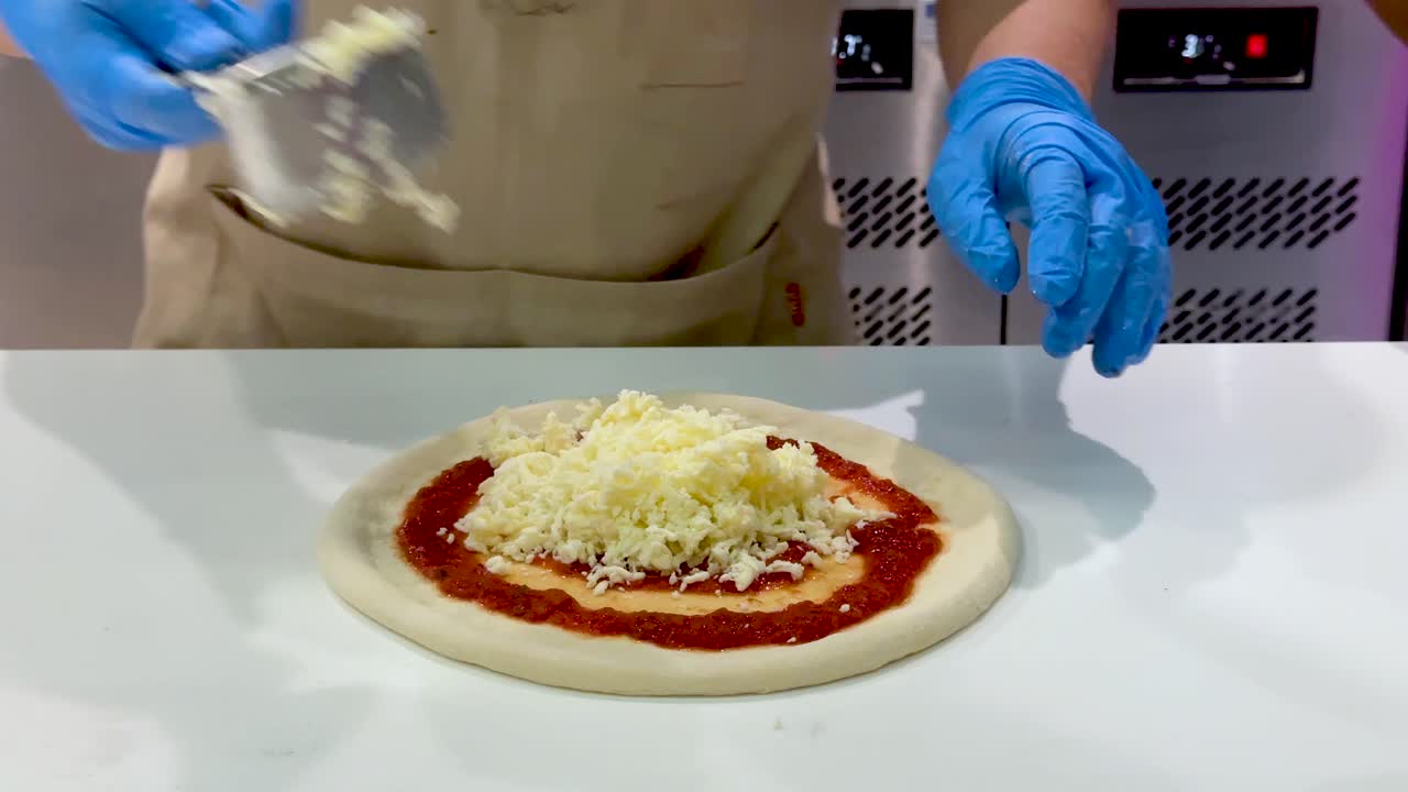 Preparing pizza with cheese and sauce