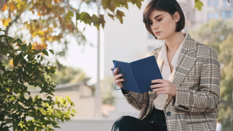 caucasian entrepreneur drawing up business plan for a month in notepad outdoor