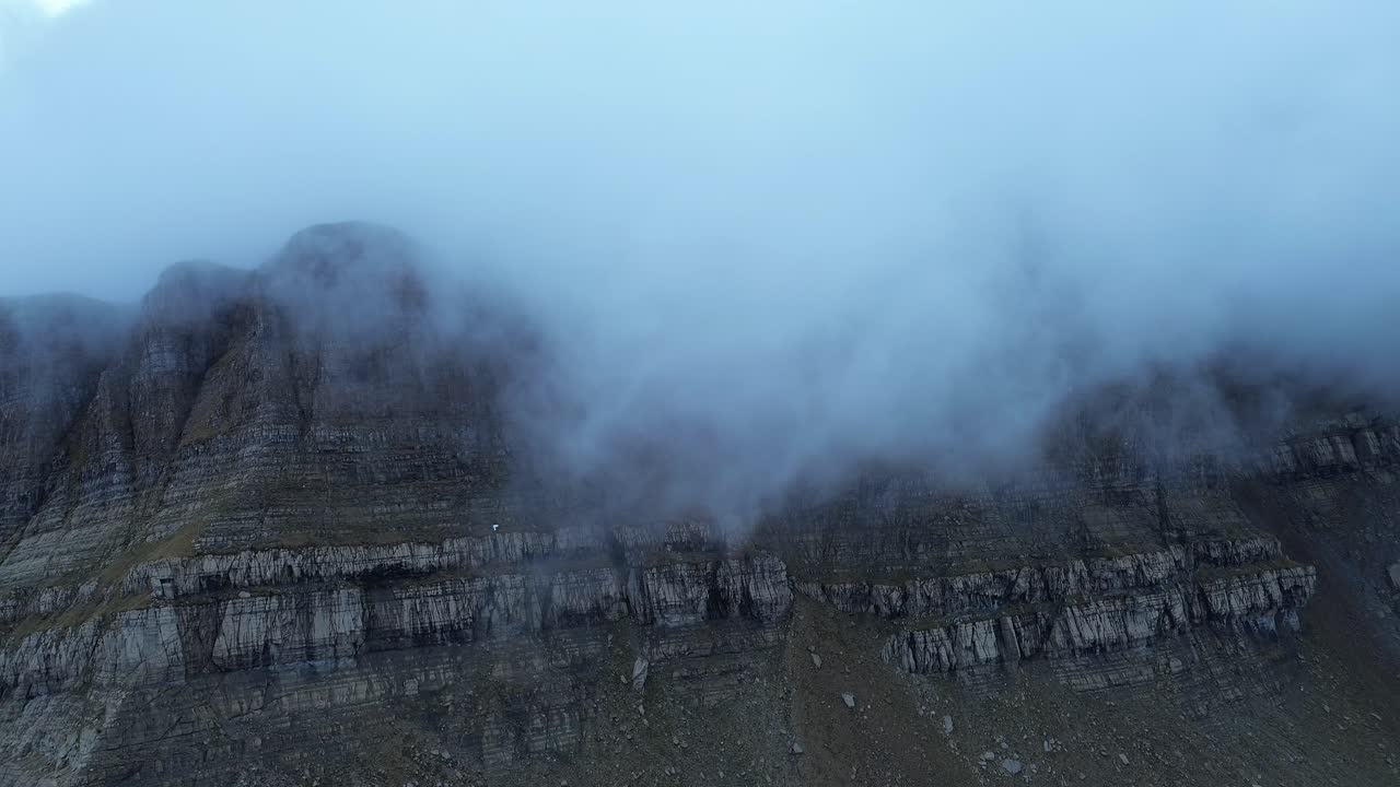 Fog drifts over Pico Tortiellas mountain, creating a mysterious atmosphere in Aragón, Spain