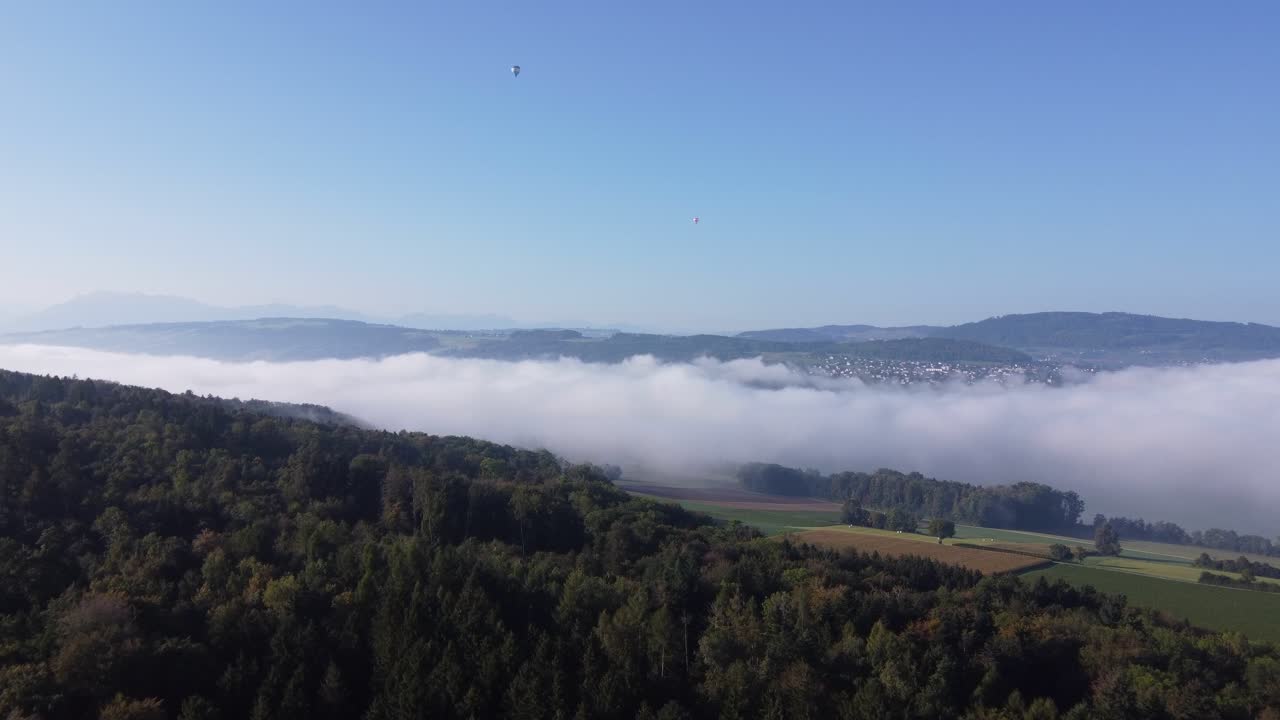 드론이 두꺼운 구름과 연기처럼 보이는 땅을 향해 날고 있습니다.