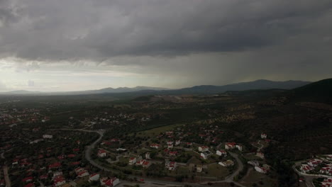 drone flying and descending over town view to cottages and green spaces greece