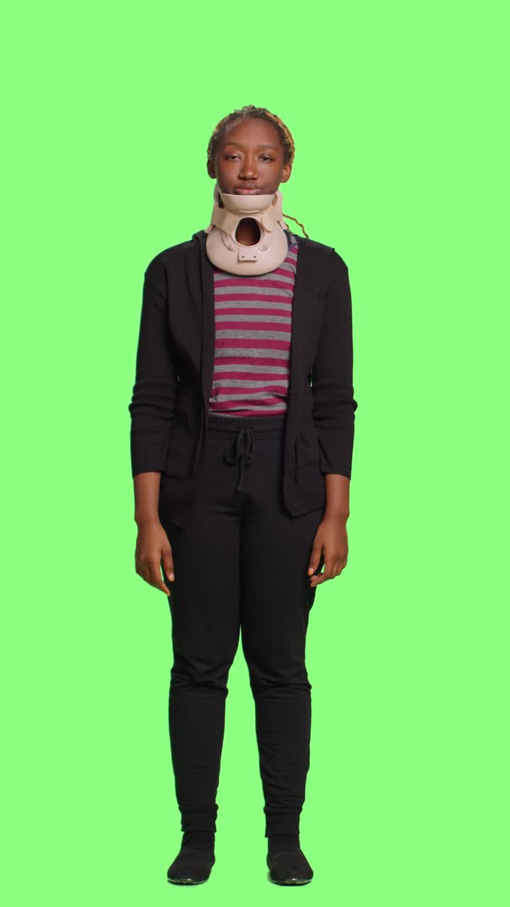 Vertical video: Unhappy woman in pain wearing cervical neck foam after fracture