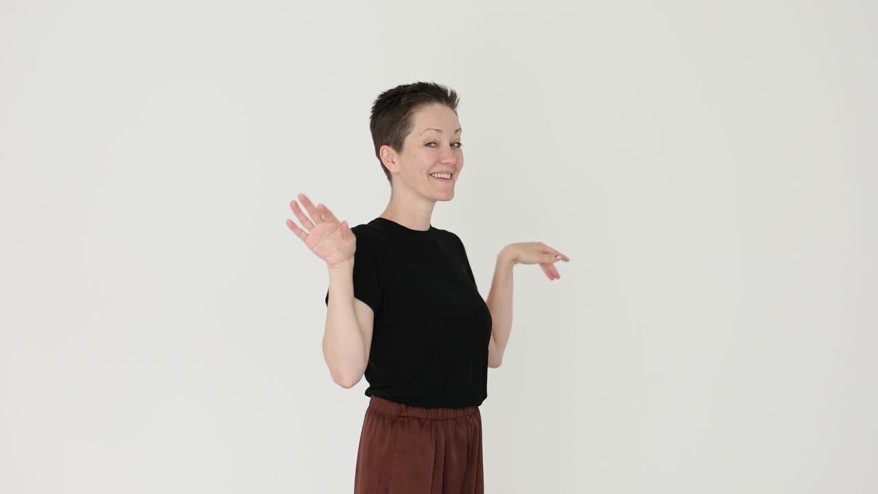 A woman with short hair gestures expressively in a studio