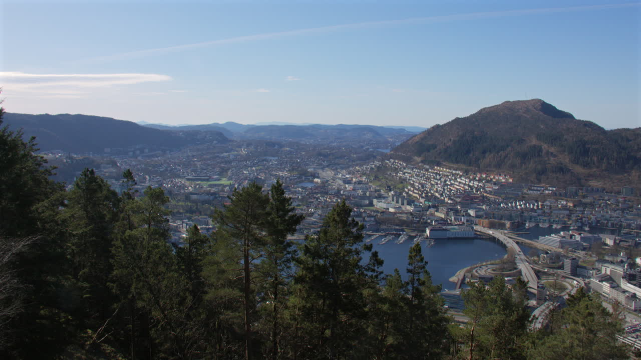 Extra wide shot of Bergen looking South with trees in foreground. Filmed from Fløyen Panorama