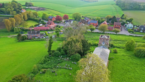 aerial drone footage captures burwell village, formerly a medieval market town, encompassing countryside fields, historic red brick houses, and the unused saint michael parish church wold hills