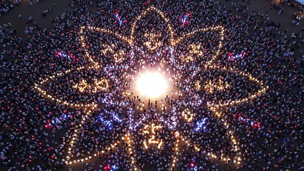 Aerial View of a Crowd Forming a Flower Pattern with Lights