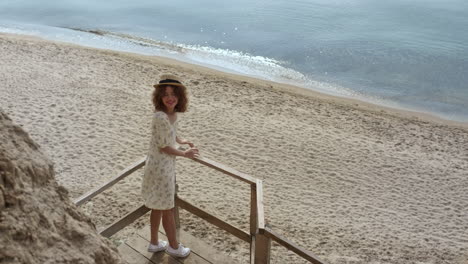 elegant lady standing stairs platform watching beach beauty. girl smiling camera