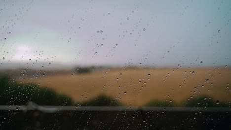 Rain-drops-on-window-in-countryside