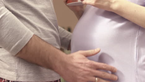 a man gently touches his pregnant wife's belly