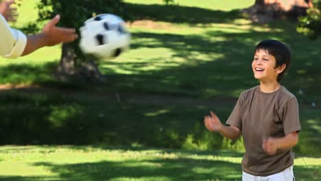 dad playing with his son with a soccer ball