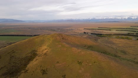 aerial view orbiting a dry hill near the southern alps of new zealand