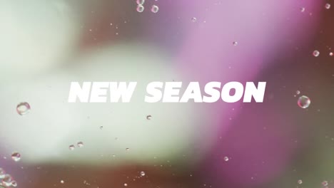 animation of new season text over close up of liquid and baubles