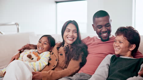 Mother,-father-and-children-watching-tv-on-sofa