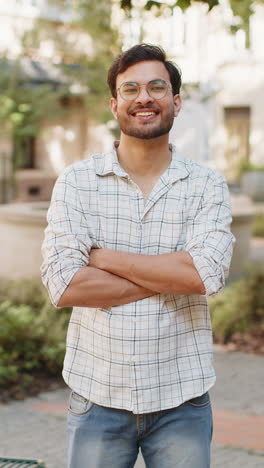 portrait of happy indian young man smiling at camera resting relaxation feel satisfied outdoors