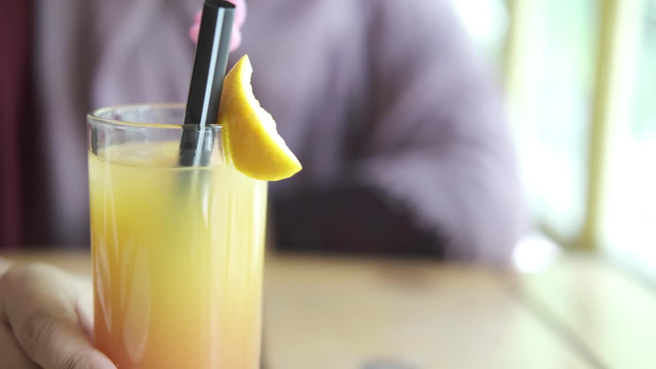 Donna che tiene un cocktail colorato