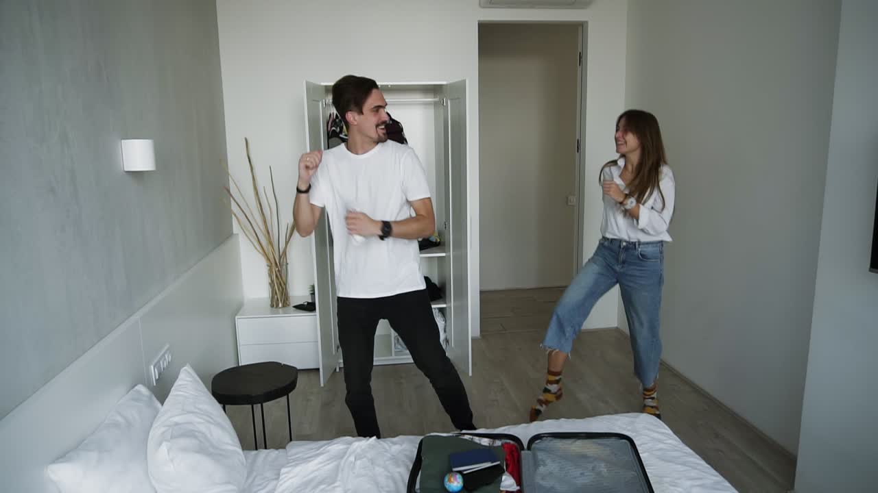 Two cool modern persons having fun together on vacation or before. Young good-looking funny couple in love dancing together in