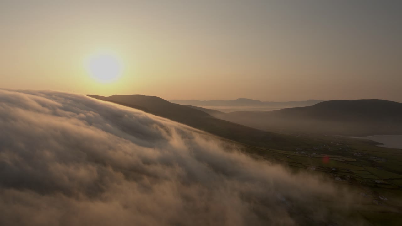 las nubes de la madrugada se desplazan sobre las montañas en co kerry irlanda mientras el sol brilla durante el verano