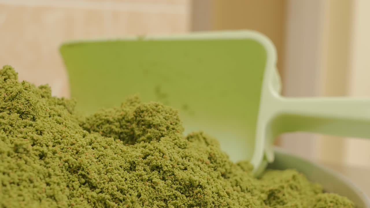 un montón de semillas de pistacho verdes molidas o trituradas y una cuchara de pastel verde. un cuenco de harina de pistacho para baklava. primer plano, disparo de dolly. 4k